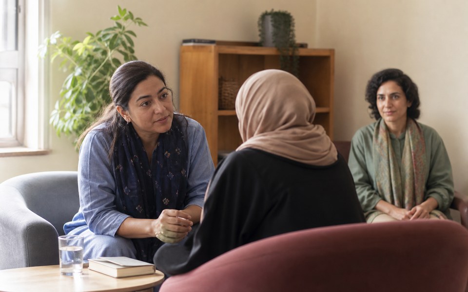Une travailleuse de la protection échange de manière confidentielle avec une femme
